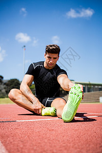 运动员在运行轨道上热身晴天运动鞋体育场精力福利耐力腿部竞赛男性能力图片