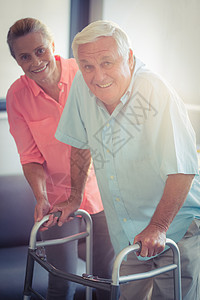 高级妇女帮助老年男子与行尸步行老年人人士女士保健退休团结微笑残障休闲治疗图片