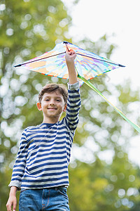 男孩在公园里拿着风筝阳光娱乐快乐休闲闲暇乐趣活动俏皮微笑农村图片