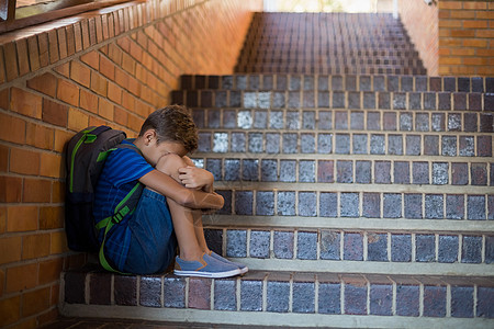 孤单地坐在楼梯上悲伤的男孩子男性学校愁云瞳孔寂寞小学生服装小学书包孤独图片