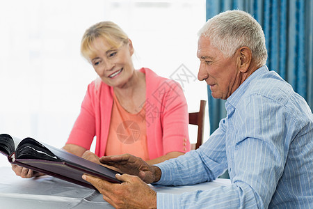 老年夫妇看相片专辑快乐医疗保险退休夫妻追忆病人药片医疗桌子回忆图片