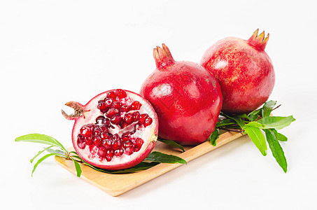 石榴水果和绿叶白色植物农业树叶绿色热带浆果种子红色叶子图片