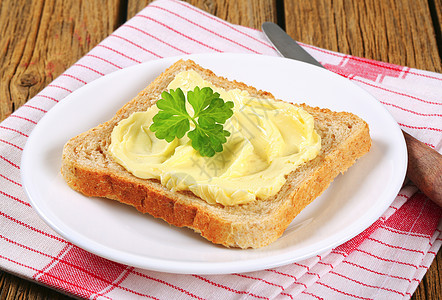 配黄油的三明治面包盘子小吃食物条纹早餐餐巾抹布乡村茶巾木头图片