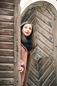 靠近旧木门的女孩房子木头毛衣裤子女性古董童年入口青年女士图片