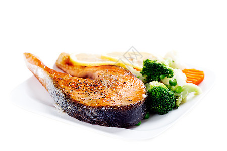 盘子上含蒸蔬菜的大灰鲑鱼 在Whit与世隔绝饮食营养美味油炸鱼片餐厅用餐牛扒炙烤柠檬图片