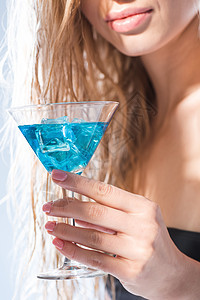 部分近视女性将鸡尾酒放在白水杯上图片