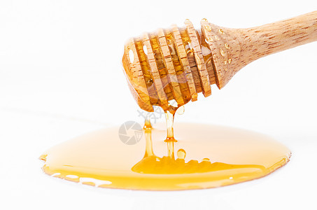 蜜糖用蜂棒滴水白色水坑木头糖浆金子饮料蜜蜂勺子食物养蜂人图片