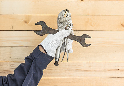 手持手套 拿着板球和可调整扳手工具建造工业维修金属工人建设者木头活动构造图片