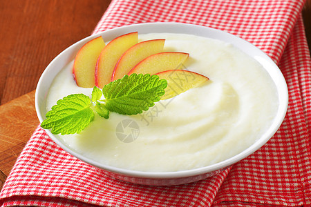 配有新鲜苹果的塞莫莉娜布丁奶制品白色红色小吃稀饭餐巾桌布奶油小菜早餐图片
