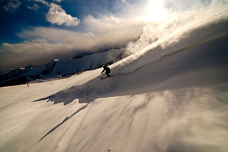 搭便车从斜坡下行运动员暴风雪乐趣自由快乐荒野粉末喜悦滑雪者男人图片