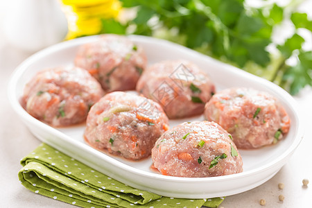 白盘上生肉丸子 在厨房做饭猪肉白色肉丸圆形饮食青菜营养香菜食物美食图片