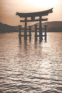 日本宫岛漂浮的Otorii门宗教寺庙神道橙子遗产神社天空太阳牌坊场景图片