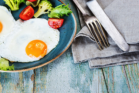 番茄炒鸡蛋两个炒鸡蛋和蔬菜蛋黄美食烹饪陶器早餐餐巾亚麻两叉盘子木头背景