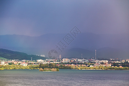 山丘后面湖边的小镇 春雨和暴风山麓天气农村耕地场景爬坡环境村庄农场草地图片