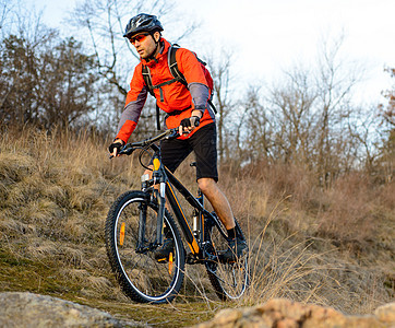 在落石轨上骑着山堤的骑着山地自行车 极端体育概念 文字空间森林踪迹冒险车轮娱乐速度爬坡男人活动男性图片
