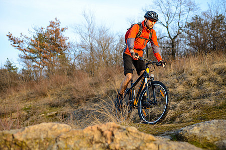在落石轨上骑着山堤的骑着山地自行车 极端体育概念 文字空间下坡运动男性森林娱乐岩石速度车轮耐力骑士图片