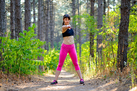 年轻的健身女人在松林中伸展 做伸展运动的女赛跑者 健康的生活方式概念衣服赛跑者女性训练成人身体运动员慢跑者锻炼木头图片