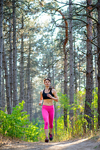 年轻女子在美丽的野生松树林的轨迹上奔跑 活跃的生活方式概念 文字空间橙子踪迹保健女性公园小路训练女士运动松树背景图片