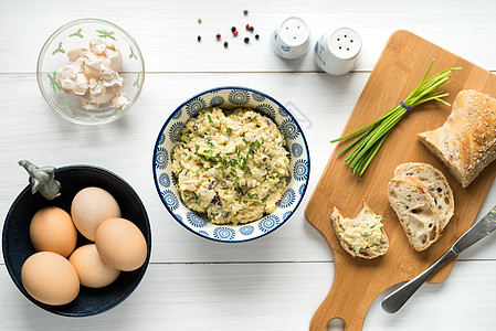 鸡蛋沙拉在碗里塞满了香肠 在白桌壁上安排胡椒桌子切菜板美食木头洋葱砧板韭菜蔬菜摄影图片