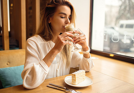 在咖啡馆喝拿铁的年轻美女餐厅饮料女孩金发女郎女性成人杯子咖啡咖啡店女士图片