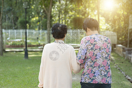 亚裔老年妇女在户外公园中走动图片