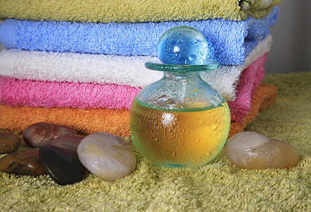 含按摩油的蓝色瓶子治疗温泉热带假期服务冥想精神芳香鹅卵石石头图片