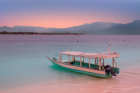 印度尼西亚Gili Meno岛海滩上的传统船海浪山脉运输海洋图片