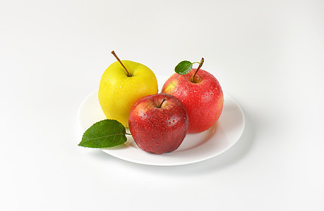 盘子上三个苹果黄色水果红色食物图片