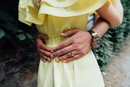 男人的手放在一个穿着黄色连衣裙的女孩的腰上 男人把手放在女孩的腰上 恩爱夫妻图片
