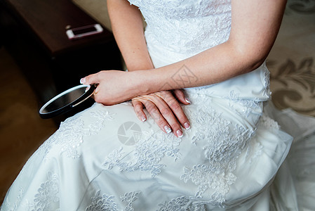 穿着白色婚纱的新娘坐着 手拿着镜子图片
