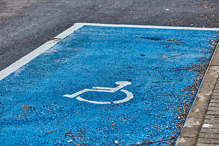 沥青上涂抹的禁用符号轮椅风化白色残障车轮人士运输蓝色人行道医疗图片