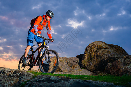 赛车手骑着山上摩托 在美丽日落的春落轨上 极端体育和冒险概念娱乐男性成人山地车运动员踪迹活动爬坡男人速度图片