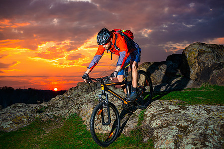 赛车手在美丽的日落山边骑着 极具活力的运动和冒险概念 的自行车下春落雪山活动骑士岩石成人乐趣下坡娱乐踪迹竞赛男性图片