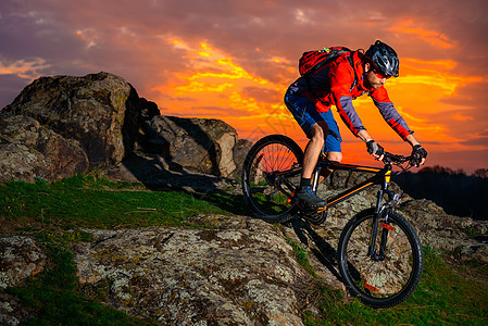 赛车手在美丽的日落山边骑着 极具活力的运动和冒险概念 的自行车下春落雪山行动竞赛男性岩石娱乐活动成人男人运动员山地车图片