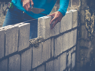 砖砖建工是建筑墙壁石匠房子石头石工工作男人水泥瓦工砖块工人图片