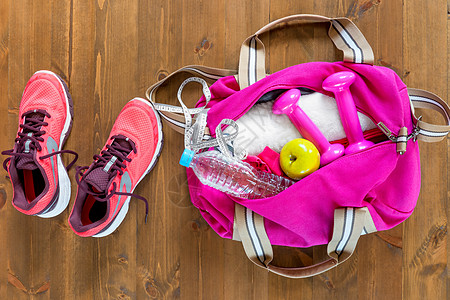 露天运动袋和粉红色跑鞋 在木地板上图片
