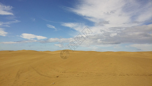 西班牙马斯帕洛马斯阳光日美丽的沙丘景观海滩山脉质地沙地全景自然景观蓝天蓝天白云图片