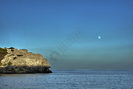 地中海边缘的岩石悬崖 海边地平线蓝色天空月亮海岸绿色石头支撑图片