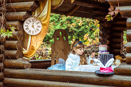眼前的景象 一个小美少女拿着一块蛋糕 在桌子上的勺子上童话微笑童年想像力文化女性发型野餐魔法乐趣图片