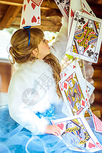 一个美丽的小女孩 玩耍和跳舞 用大牌在桌上打牌的游戏化妆品孩子艺术仙境戏服创造力故事想像力头发闲暇背景图片