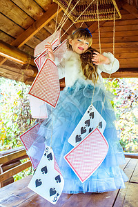 一个美丽的小女孩 玩耍和跳舞 用大牌在桌上打牌的游戏女孩故事想像力魔法闲暇化妆品蓝色戏服仙境创造力背景图片
