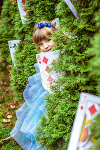 一个穿长蓝色裙子的漂亮小姑娘 看着从壁树下面看故事魔法学习女孩旅行创造力艺术想像力金发女郎头发背景图片