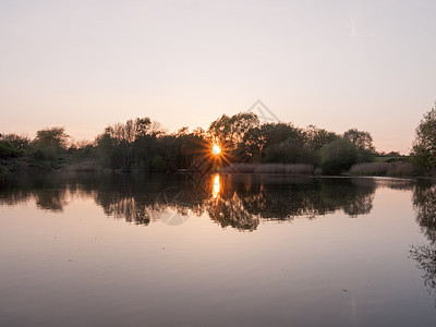 美丽的太阳在春天的湖面上落下 与太阳环球相伴图片