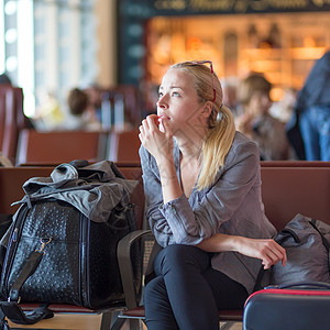 女人在机场候机站等着旅行民众旅行者乘客时间过境手提女性服务火车图片