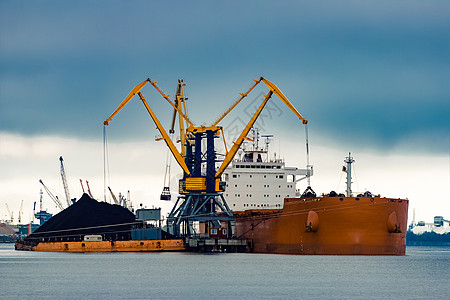 大型橘橙色货船装载物流货运进口加载货物出口卸载橙子起重机港口图片