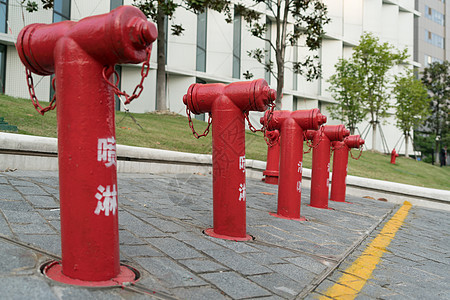 大楼旁边有一群红火水合水栓消防栓预防公用事业管子街道危险控制灭火器金属工具图片