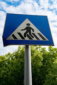 带有蓝天空和绿树的行人符号或横行标志穿越城市警告天空插图路标男人信号运输交通图片