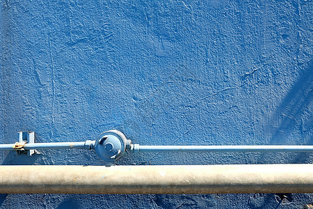 旧管道与蓝色水泥纹理墙背景图片