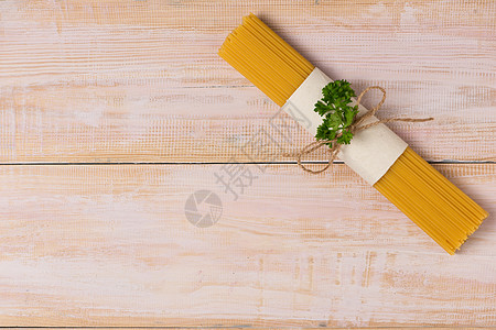黑木桌上绑着绳子的干意面意大利面糊黄色美食白色面条食物工作室图片