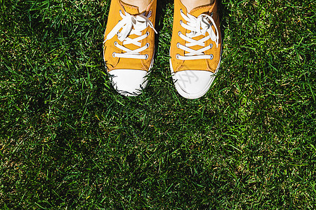 绿色草地上的老黄色脚鞋 从上面看青少年牛仔裤姿势幸福自由成人蓝色街道运动鞋衣服图片